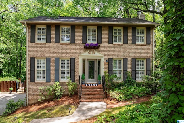 2017 Crossvine Rd, Hoover, AL 35244 - colonial inspired home with brick siding, fence, a chimney, and entry steps