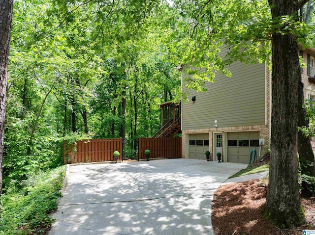 2017 Crossvine Rd, Hoover, AL 35244 - view of property exterior with fence, an attached garage, brick siding, stairway, and concrete driveway