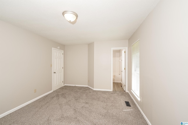 carpeted spare room with baseboards and visible vents