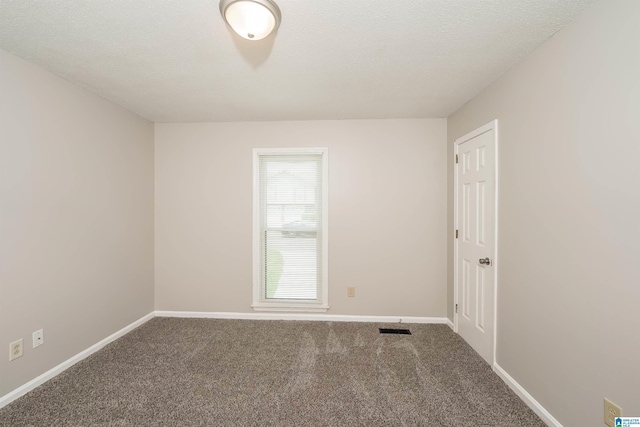 carpeted spare room with visible vents, a textured ceiling, and baseboards