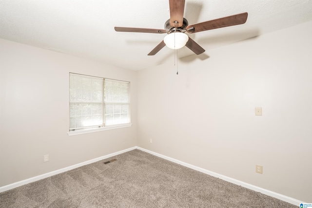 spare room with visible vents, carpet flooring, baseboards, and ceiling fan