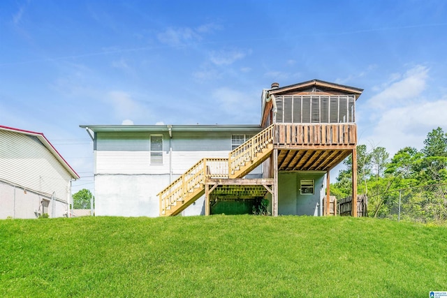 back of property featuring fence, a yard, a sunroom, and stairway