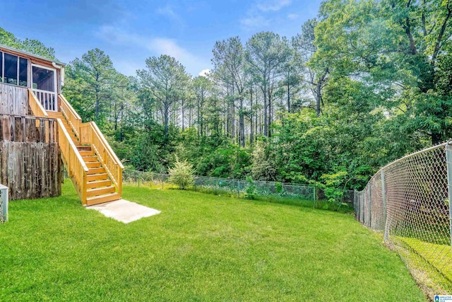 view of yard with stairs, a fenced backyard, and a sunroom