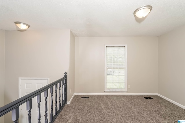 empty room with baseboards, carpet flooring, and visible vents
