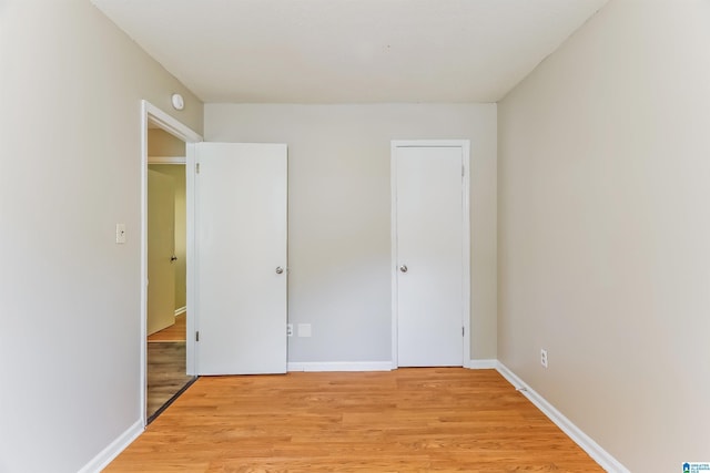 unfurnished bedroom featuring baseboards and light wood-style floors