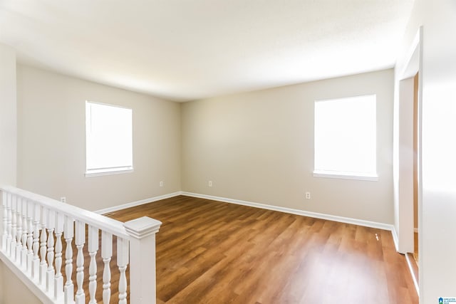 spare room featuring baseboards and wood finished floors