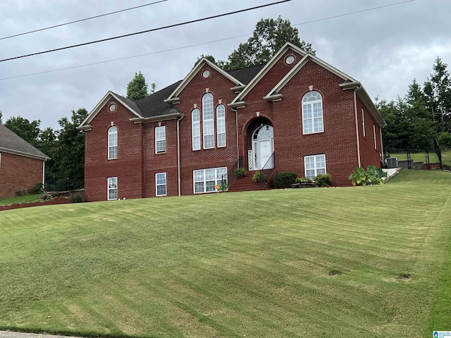 split foyer home with brick siding, a front lawn, and cooling unit
