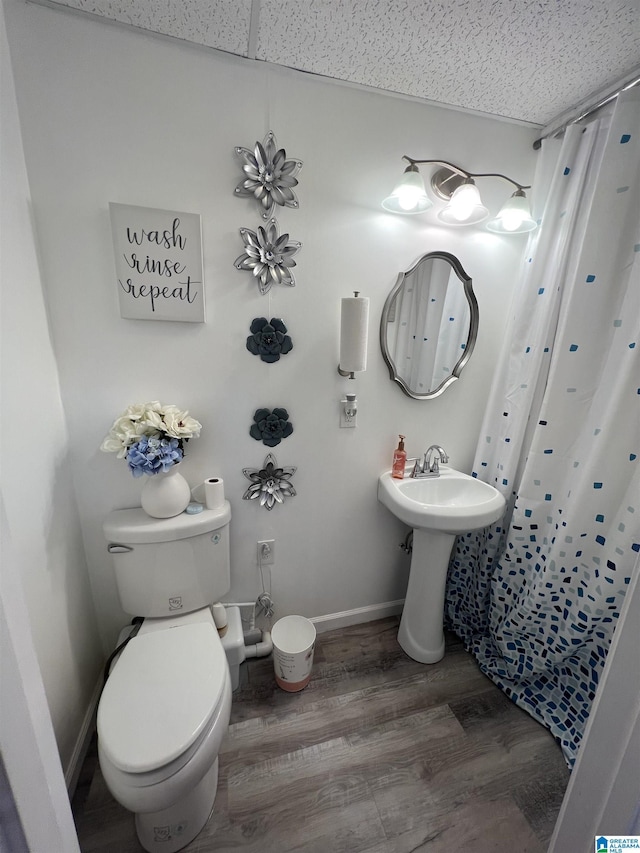 bathroom with toilet, baseboards, wood finished floors, and a shower with curtain