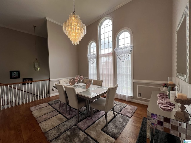 dining space featuring an inviting chandelier, ornamental molding, and wood finished floors