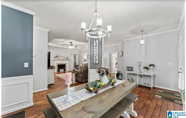 107 Magnolia Ridge Cir, Chelsea, AL 35043 - dining space featuring crown molding, wood-type flooring, ceiling fan with notable chandelier, and a fireplace