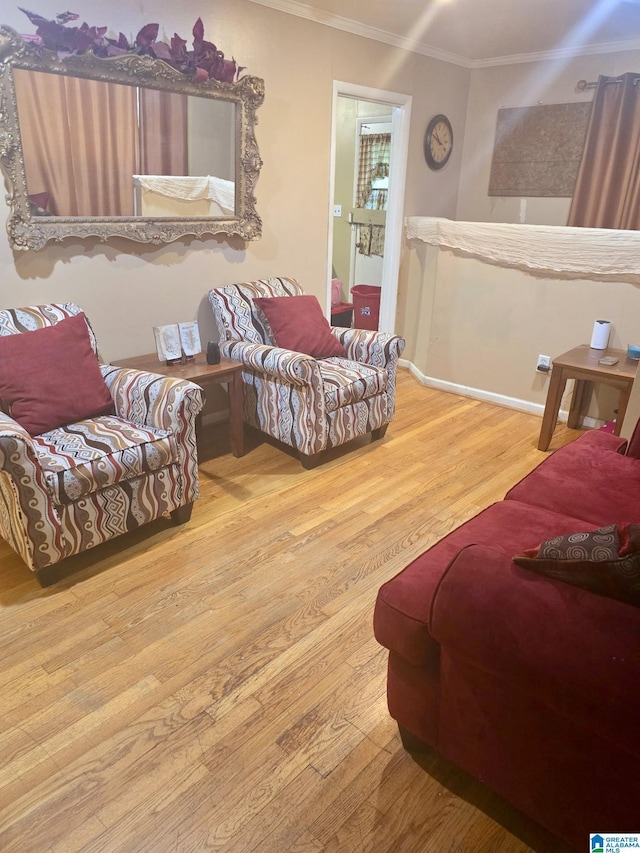 living room featuring baseboards, ornamental molding, and wood finished floors