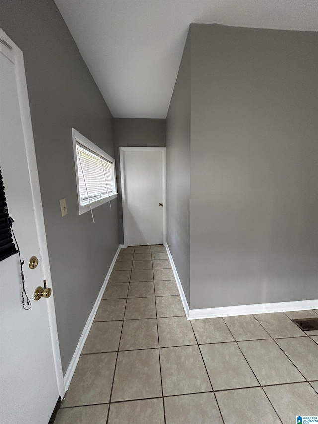 hall with baseboards and light tile patterned floors