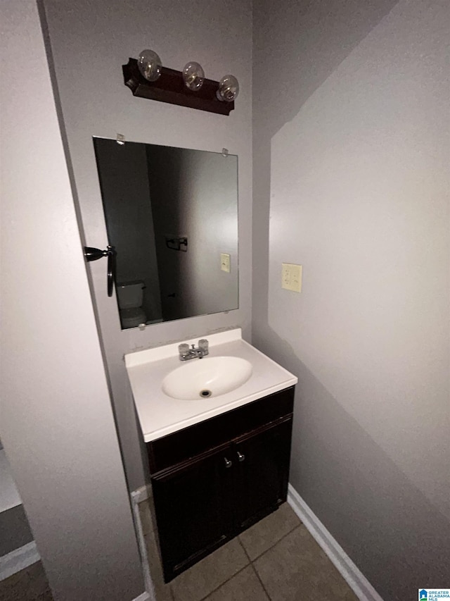 bathroom with vanity, tile patterned flooring, and baseboards