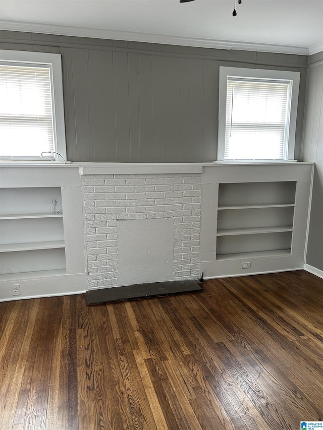 unfurnished room featuring crown molding, built in features, and wood finished floors