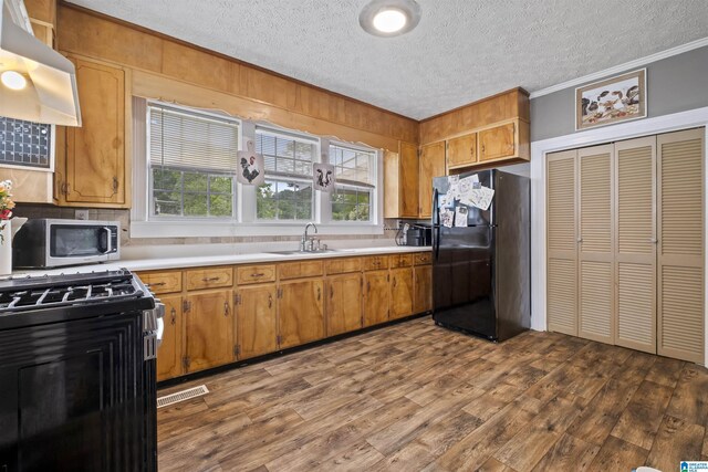 2857 Alexandria Wellington Rd, Alexandria, AL 36250 - kitchen with range with gas stovetop, freestanding refrigerator, ornamental molding, stainless steel microwave, and a sink