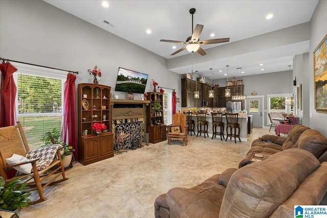 living area featuring recessed lighting, ceiling fan, visible vents, and a wealth of natural light