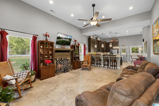 living room with a ceiling fan, visible vents, plenty of natural light, and recessed lighting