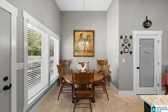dining area featuring an inviting chandelier and baseboards