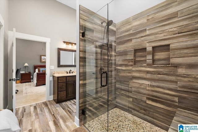 full bathroom with vanity, wood finished floors, a towering ceiling, and a stall shower