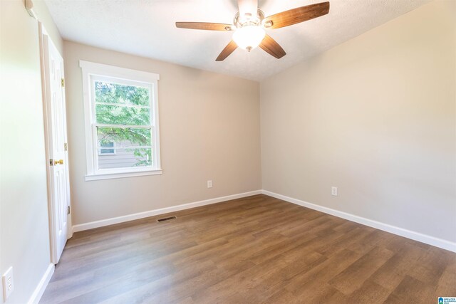 unfurnished room with a ceiling fan, baseboards, visible vents, and wood finished floors