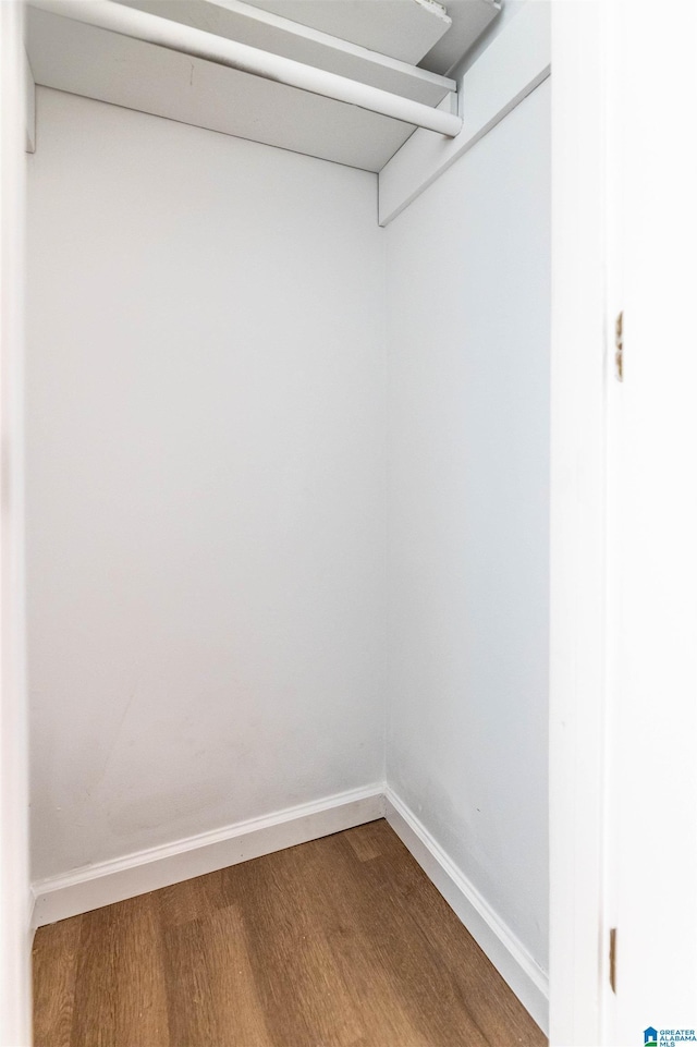 walk in closet with wood finished floors