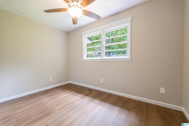 spare room with a ceiling fan, baseboards, and wood finished floors