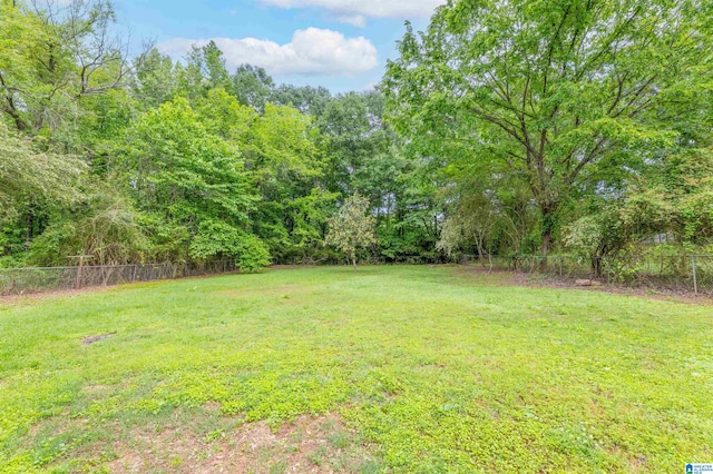 view of yard featuring a view of trees and fence