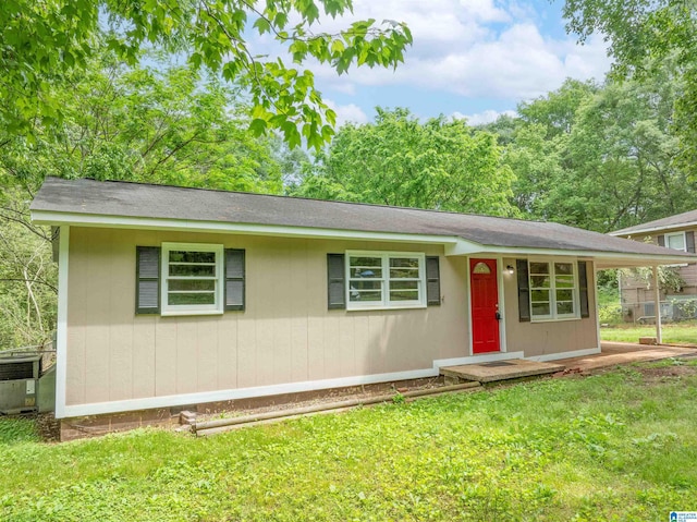 ranch-style house featuring central air condition unit and a front yard