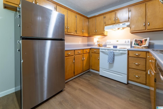 kitchen featuring dark wood-style flooring, electric range, light countertops, freestanding refrigerator, and under cabinet range hood