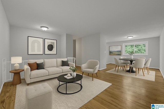 living area with baseboards and wood finished floors