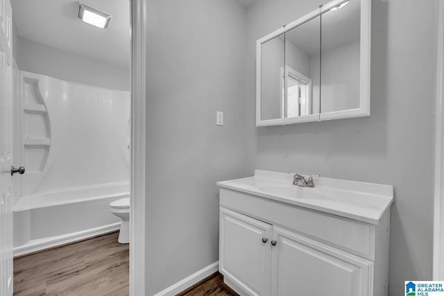 full bath with vanity, wood finished floors, bathtub / shower combination, and toilet