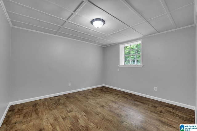 empty room with crown molding, baseboards, and wood finished floors