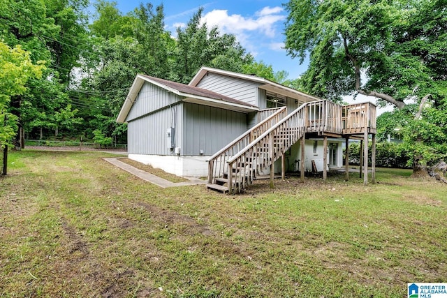back of property featuring stairway, a yard, and a wooden deck