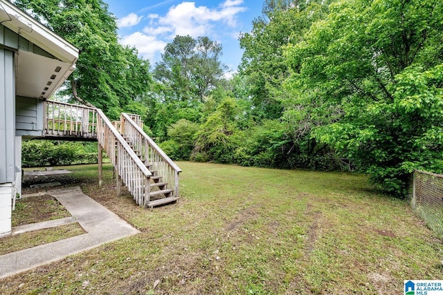 view of yard with fence, stairway, and a deck