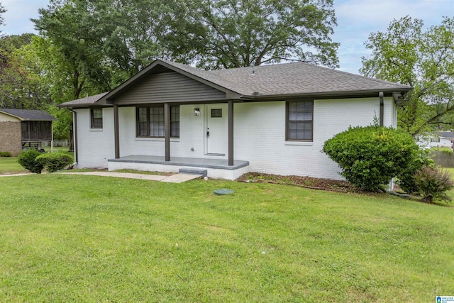 733 Heflin Ave E, Birmingham, AL 35214 - view of front of home featuring roof with shingles, covered porch, a front lawn, and brick siding