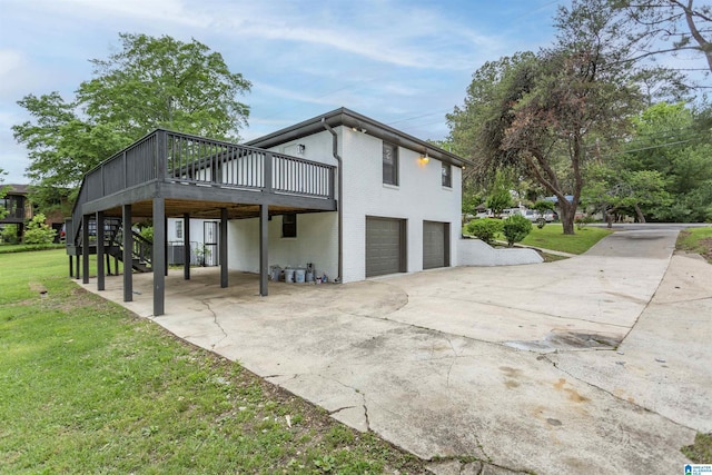 733 Heflin Ave E, Birmingham, AL 35214 - view of side of property featuring stairs, a garage, a wooden deck, concrete driveway, and a lawn