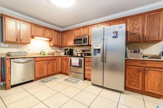 kitchen with crown molding, tasteful backsplash, brown cabinetry, and stainless steel appliances