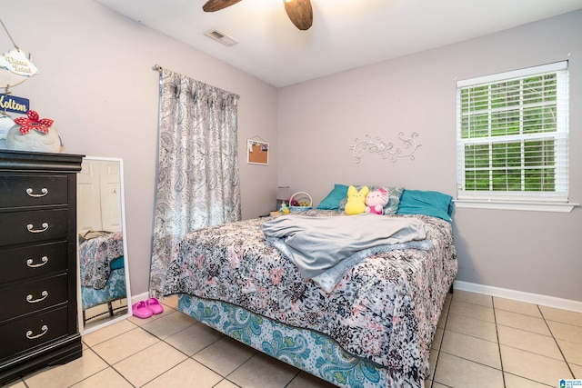 bedroom featuring ceiling fan, baseboards, visible vents, and light tile patterned floors