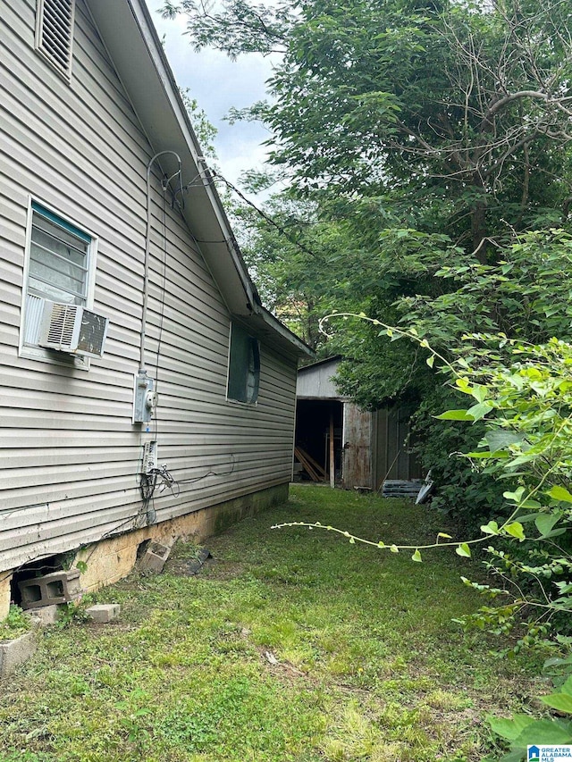 view of home's exterior with a storage unit, an outdoor structure, and cooling unit
