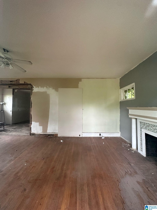 unfurnished living room featuring a ceiling fan, hardwood / wood-style flooring, and a tile fireplace