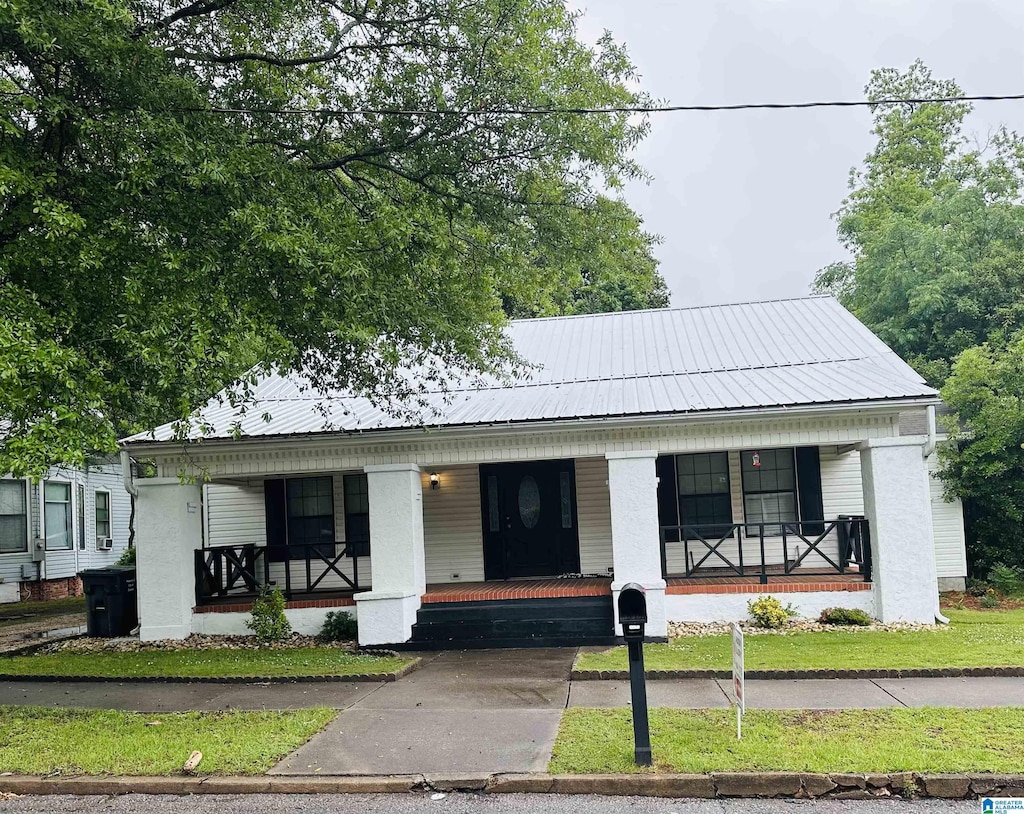 view of front facade featuring a porch and metal roof
