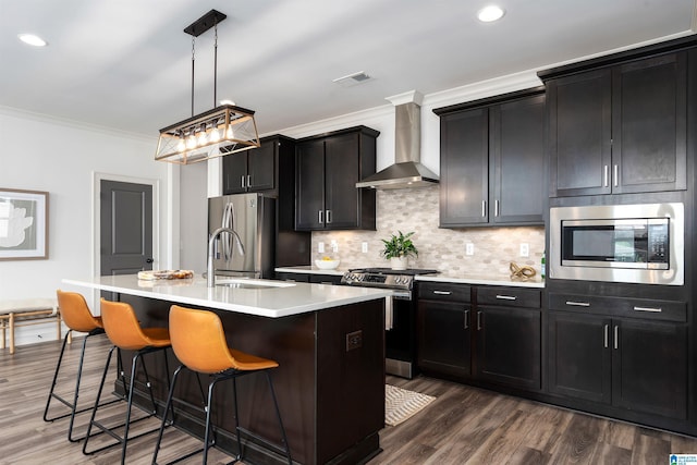 3304 Trip Run, Hoover, AL 35244 - kitchen with appliances with stainless steel finishes, wall chimney exhaust hood, a sink, ornamental molding, and a kitchen island with sink