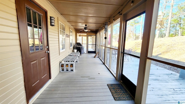 unfurnished sunroom featuring a ceiling fan