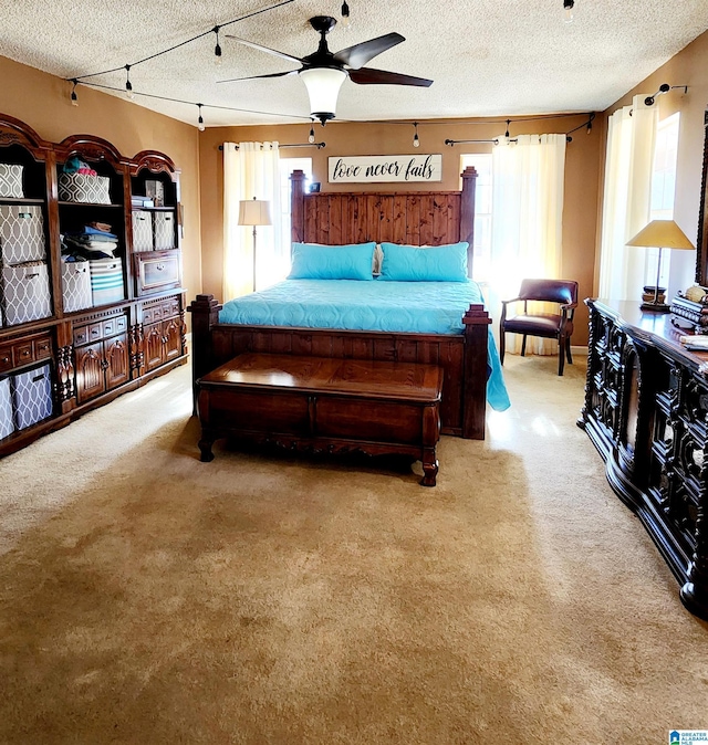 bedroom featuring a textured ceiling, carpet, and a ceiling fan