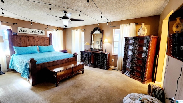 carpeted bedroom featuring a ceiling fan and a textured ceiling