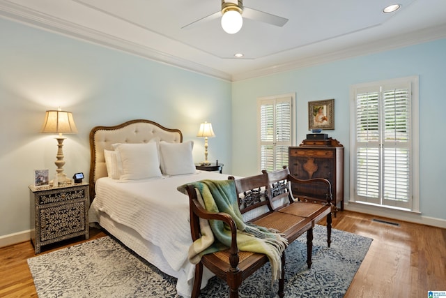bedroom with baseboards, ornamental molding, and wood finished floors
