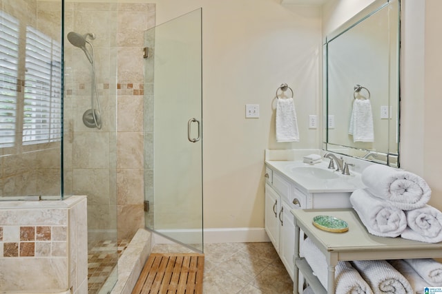 bathroom with tile patterned floors, baseboards, vanity, and tiled shower