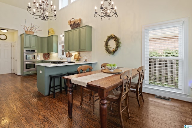 dining area featuring an inviting chandelier, dark wood-style floors, and a wealth of natural light