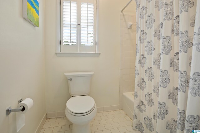 full bathroom featuring baseboards, toilet, tile patterned floors, and shower / tub combo with curtain