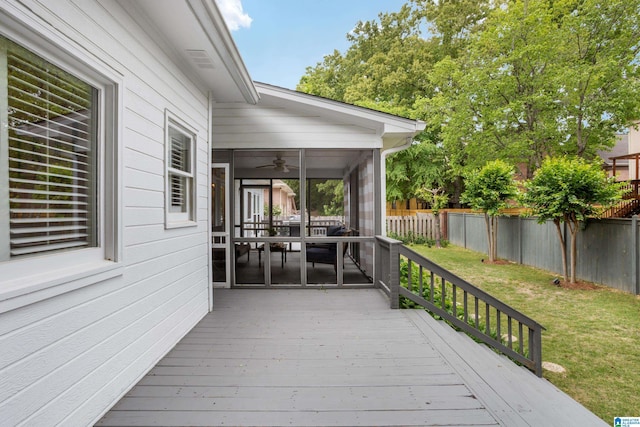 wooden deck with a fenced backyard, a yard, ceiling fan, and a sunroom